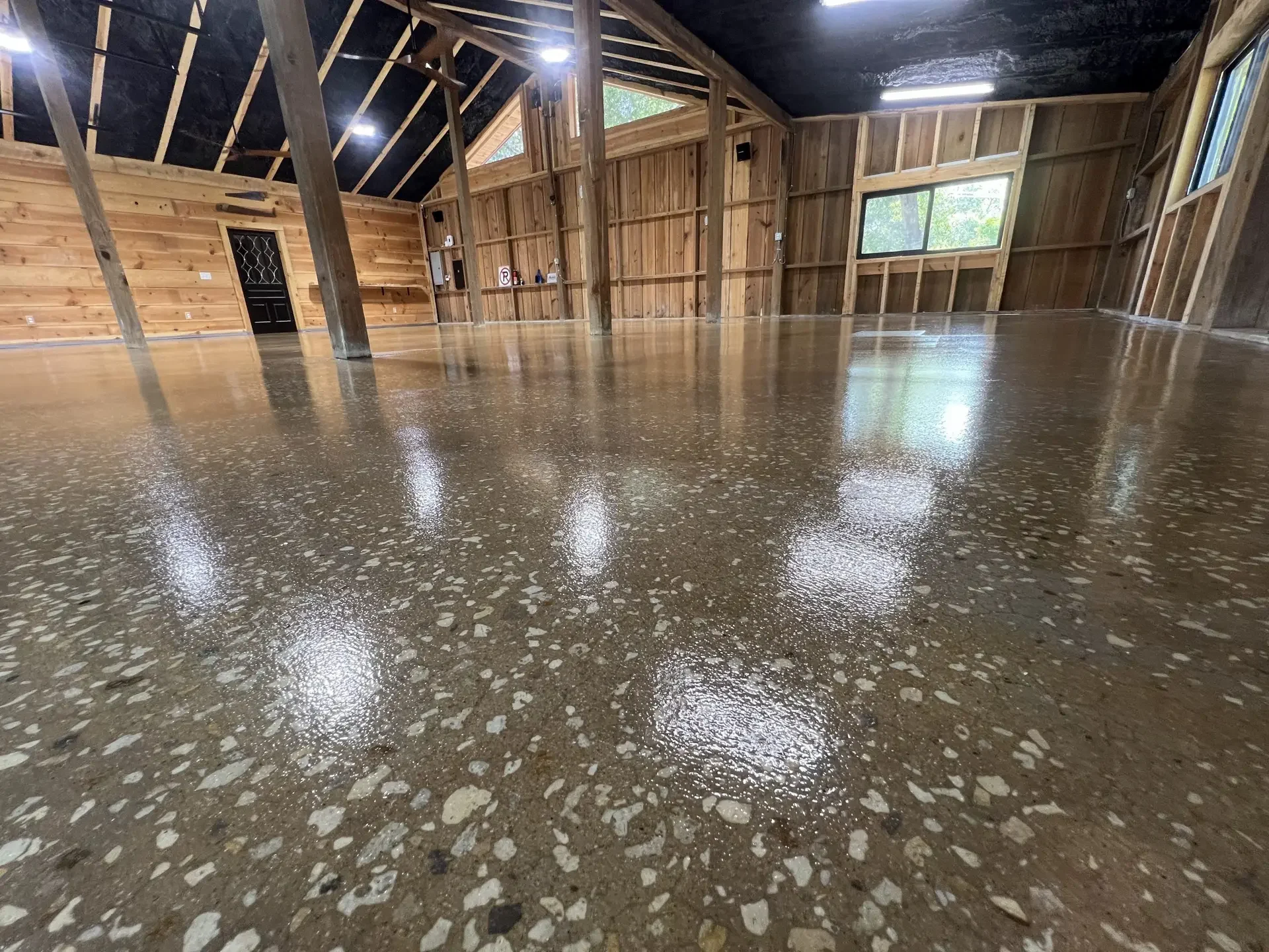 Glossy ground and sealed concrete with exposed aggregate in a timber barn